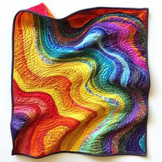 a multicolored quilt is hanging on the wall