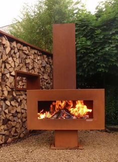 a fire pit in the middle of a yard with logs stacked on top of it