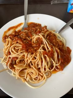 a white plate topped with spaghetti and sauce