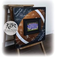 a framed football with the team's name and numbers on it is sitting in front of a chair