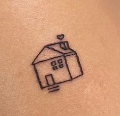 a small house tattoo on the back of a woman's stomach, with a heart above it