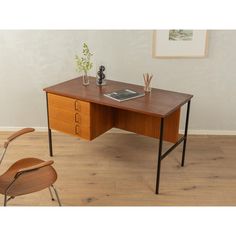 an office desk with a laptop on it and a chair in front of the desk