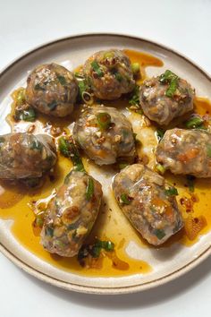 a white plate topped with meatballs covered in sauce