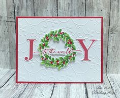 a handmade christmas card with the word joy in red and green wreaths on it