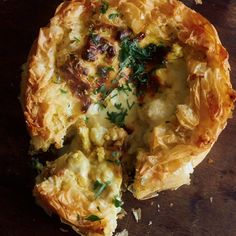 an omelet with meat and vegetables is on a wooden table