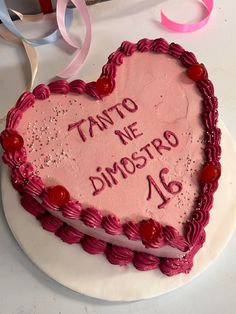 a heart shaped cake with writing on it and ribbon around the edges that says, tanto ne dimostro