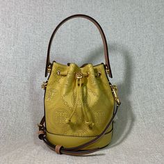 Brand New Never Been Carried Golden Sunset T Monogram Perforated Mini Bucket Bag By Tory Burch. This Bag Is Made Of Yellow Genuine Leather Dimensions: 7.2” Wide X 5.6” Tall Center X 3.3" Deep. Handle 3" Drop Long Leather Strap Is Adjustable And Detachable Strap And Handle Are In Tan Leather Drawstring Top Closure Interior: Single Compartment Microsuede Lining. Tt Logo Embossed On Bag Base Gold Tone Metalware. Yellow Bucket Bag With Gold-tone Hardware, Elegant Yellow Bucket Bag With Removable Pouch, Elegant Yellow Bucket Bag For Daily Use, Yellow Travel Bucket Bag, Elegant Yellow Bucket Bag With Adjustable Strap, Elegant Yellow Bucket Bag With Detachable Strap, Designer Yellow Pouch Bag, Elegant Yellow Bucket Bag, Luxury Yellow Bucket Bag With Removable Pouch