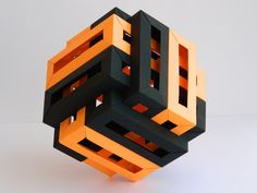 an orange and black cube is shown on a white surface with no one around it