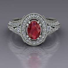 a ring with a large red stone surrounded by small white diamonds on the sides and an intricate band around it