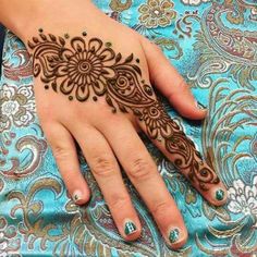 a woman's hand with henna tattoos on it