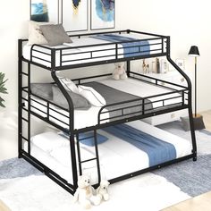 a black metal bunk bed sitting on top of a blue rug next to a white teddy bear