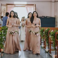 two bridesmaids walking down the aisle at a wedding