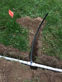 a pipe laying in the ground next to some grass