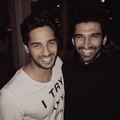 two men standing next to each other smiling