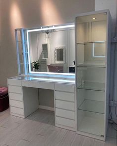 a white dressing table with lights on it