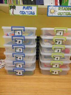 several plastic bins with numbers on them sitting next to each other in front of a bookshelf