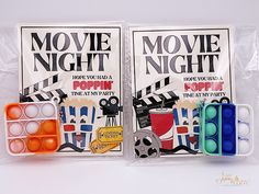 two movie night posters in plastic bags on a white surface with colored eggs and markers