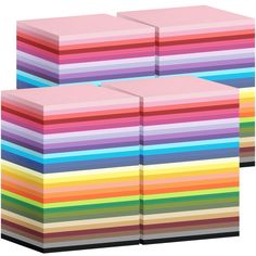 a stack of multicolored papers sitting next to each other on a white background