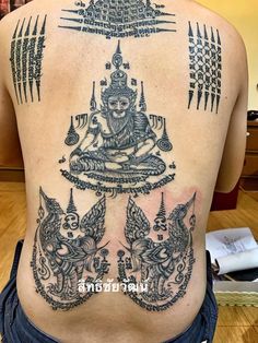 the back of a woman's body with tattoos and designs on her upper part