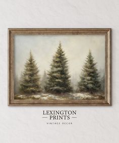 a painting hanging on the wall above a white wall with a brown frame and trees