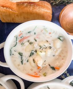 there is a bowl of soup on the table with bread and other items around it