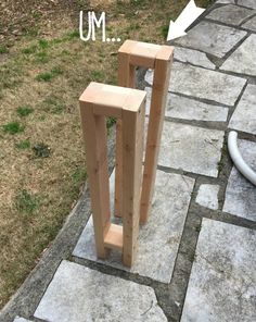 two wooden posts sitting on top of a stone walkway