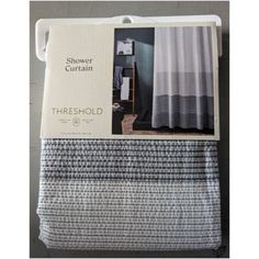 the shower curtain in grey and white is on display next to a shelf with towels