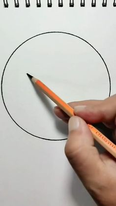 a person holding a pencil in front of a drawing circle