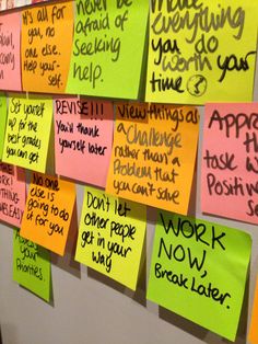 several sticky notes attached to a wall with words written on them and writing in different languages