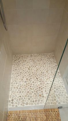 a walk in shower sitting next to a tiled floor