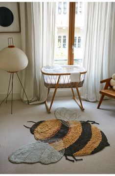 a baby crib in the corner of a room with several rugs on the floor