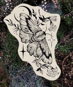 a sticker with a moth on it sitting in the grass next to some plants