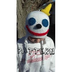 a child wearing a knitted hat with a clown face