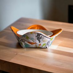 a cloth bowl sitting on top of a wooden table