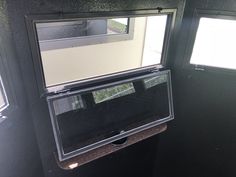 the inside of a trailer with two windows and a mirror on the side of it