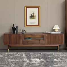 a living room scene with focus on the entertainment center and painting hanging over it's sideboard