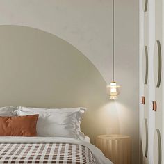 a bed with white sheets and brown pillows in a bedroom next to a wall light