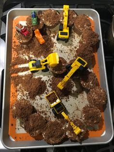 there are construction vehicles in the dirt on this baking sheet, and they're ready to be made into cupcakes