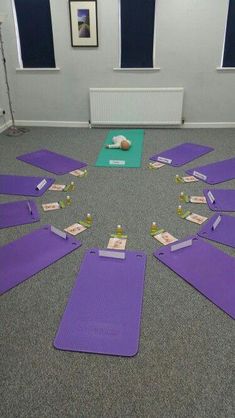 yoga mats laid out on the floor in a circle with sticky notes pinned to them