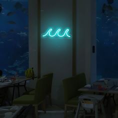 a neon sign that is on the side of a wall next to some tables and chairs