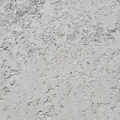 a white stucco wall with small cracks in it