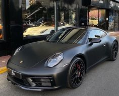 a black sports car parked in front of a store