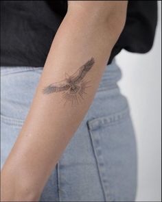 a woman's arm with a bird tattoo on the left side of her arm