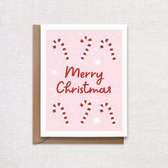 a pink christmas card with candy canes on it