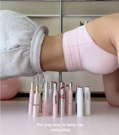 a woman in pink panties is bending over with her legs on the counter next to several lipstick tubes