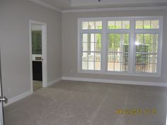 an empty living room with no furniture in it, and the door is open to another room