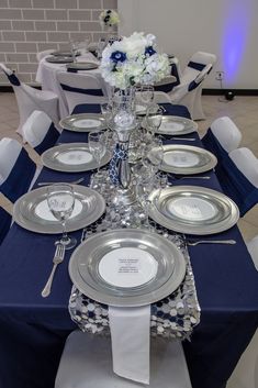 the table is set with silver and white plates