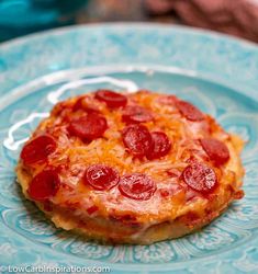 a pepperoni pizza sitting on top of a blue plate