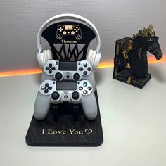 a video game controller sitting on top of a table next to a black horse statue