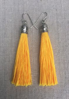 Chic yellow tassel earrings!  They would add a pop of color to any outfit for any occasion.  Dress them up or down.  They are timeless and versatile.  They are lightweight, fun and unique!The tassels measure 2 1/8” long by 1/4” wide.  They hang from simple silver ear wire hooks.  Overall drop length is about 2 1/4”.  Metal is allergy free plated silver.These are my latest creation!  I have them available in many colors!  Find them all under the category tassel earrings in my shop.Thanks for stop Yellow Dangle Tassel Earrings Gift, Yellow Tassel Earrings As Gift, Yellow Fringe Earrings As Gift, Yellow Fringe Jewelry Gift, Yellow Fringe Jewelry For Gift, Yellow Statement Earrings, Yellow Tassel Earrings, Acorn Jewelry, Green Tassel Earrings